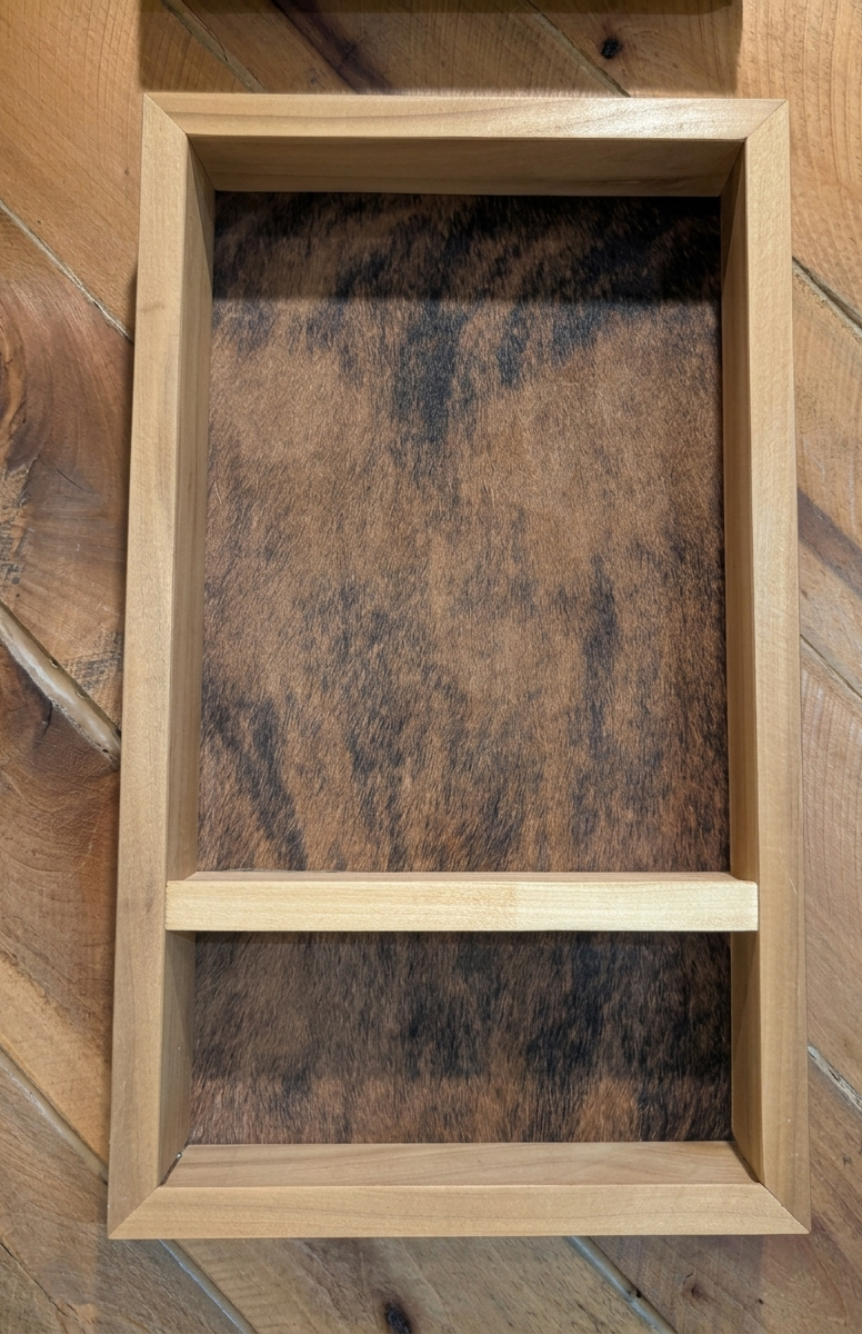 A natural custom wood belt buckle display hanging on a wooden rustic wall.