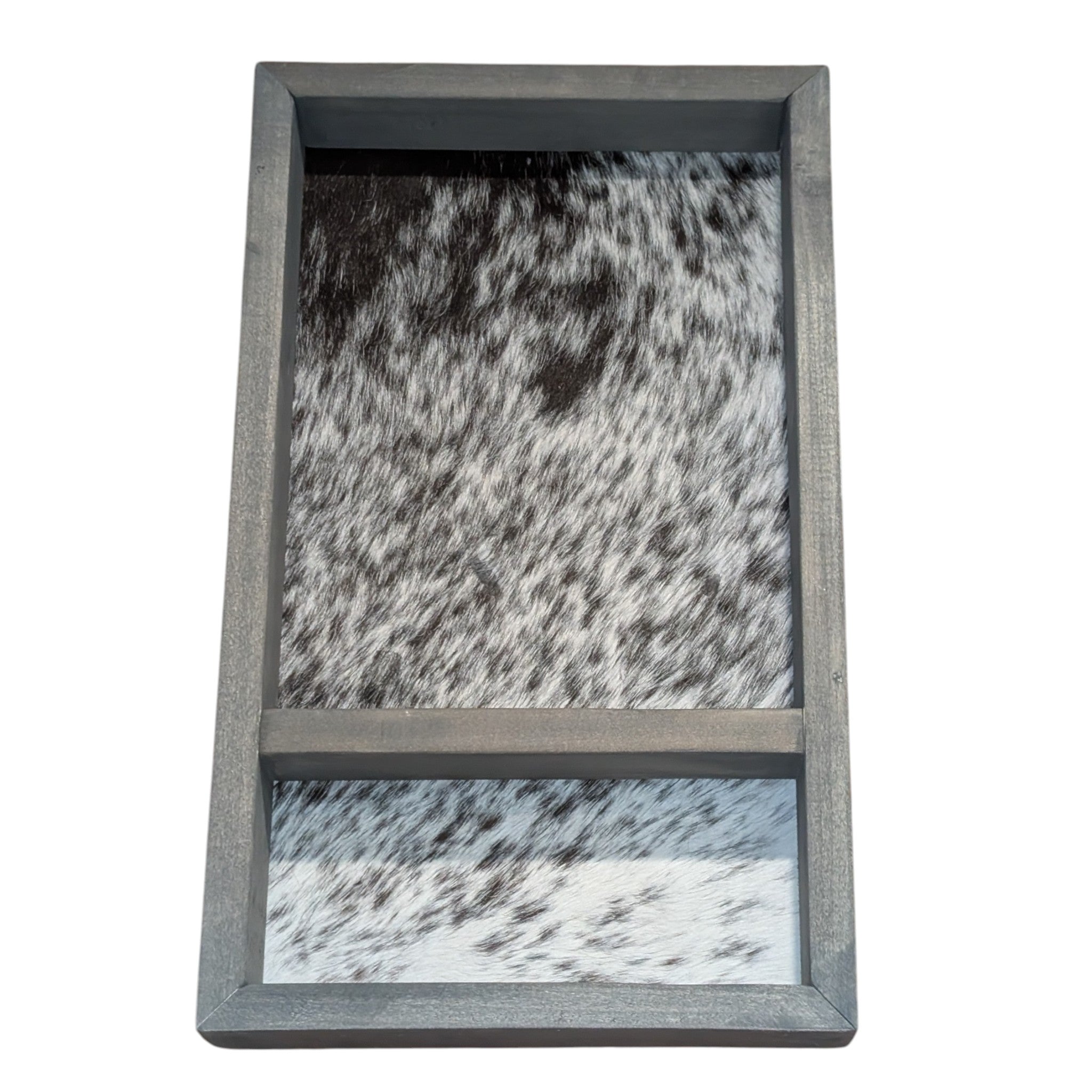 A rustic wooden belt buckle case with a black and white speckled cowhide backing