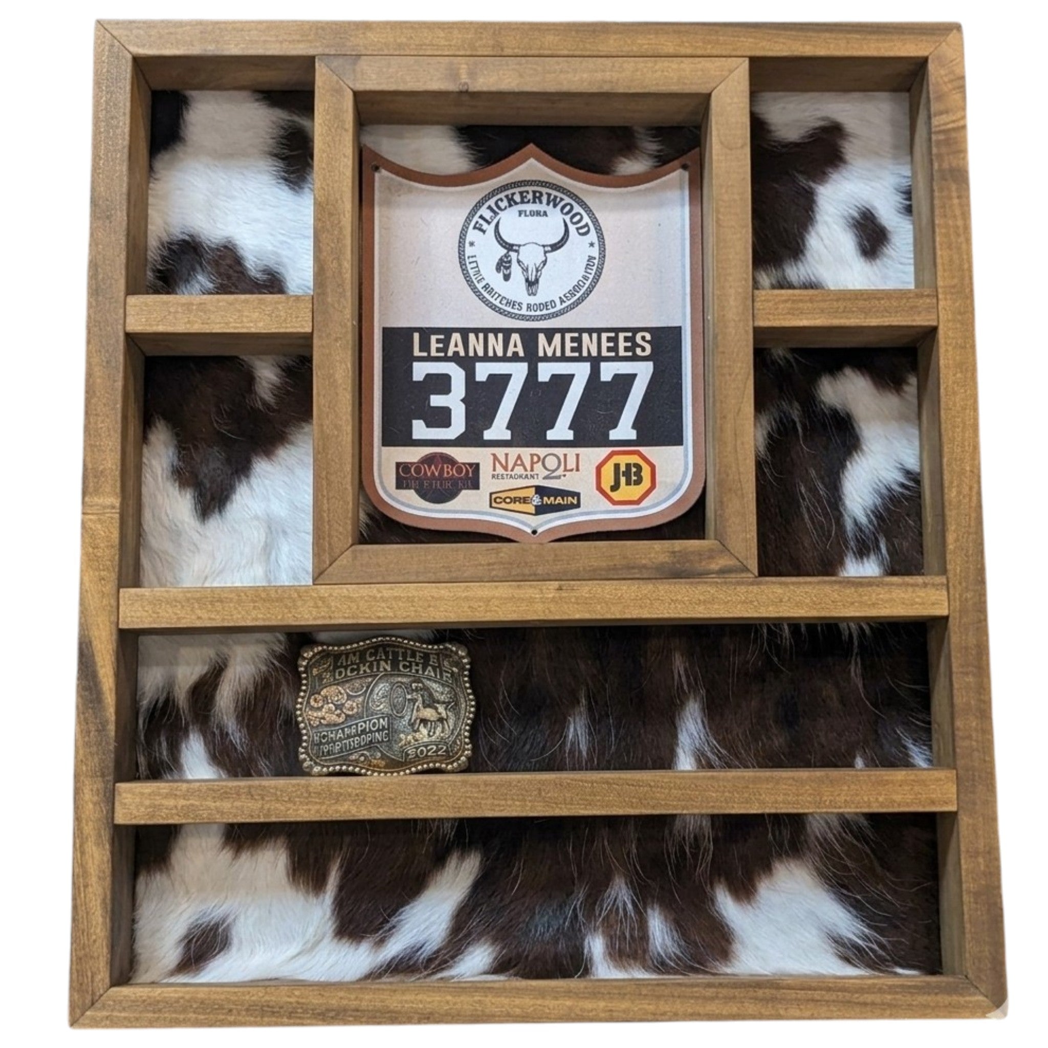 A rustic handcrafted dark walnut wooden belt buckle and knife display with genuine cowhide.