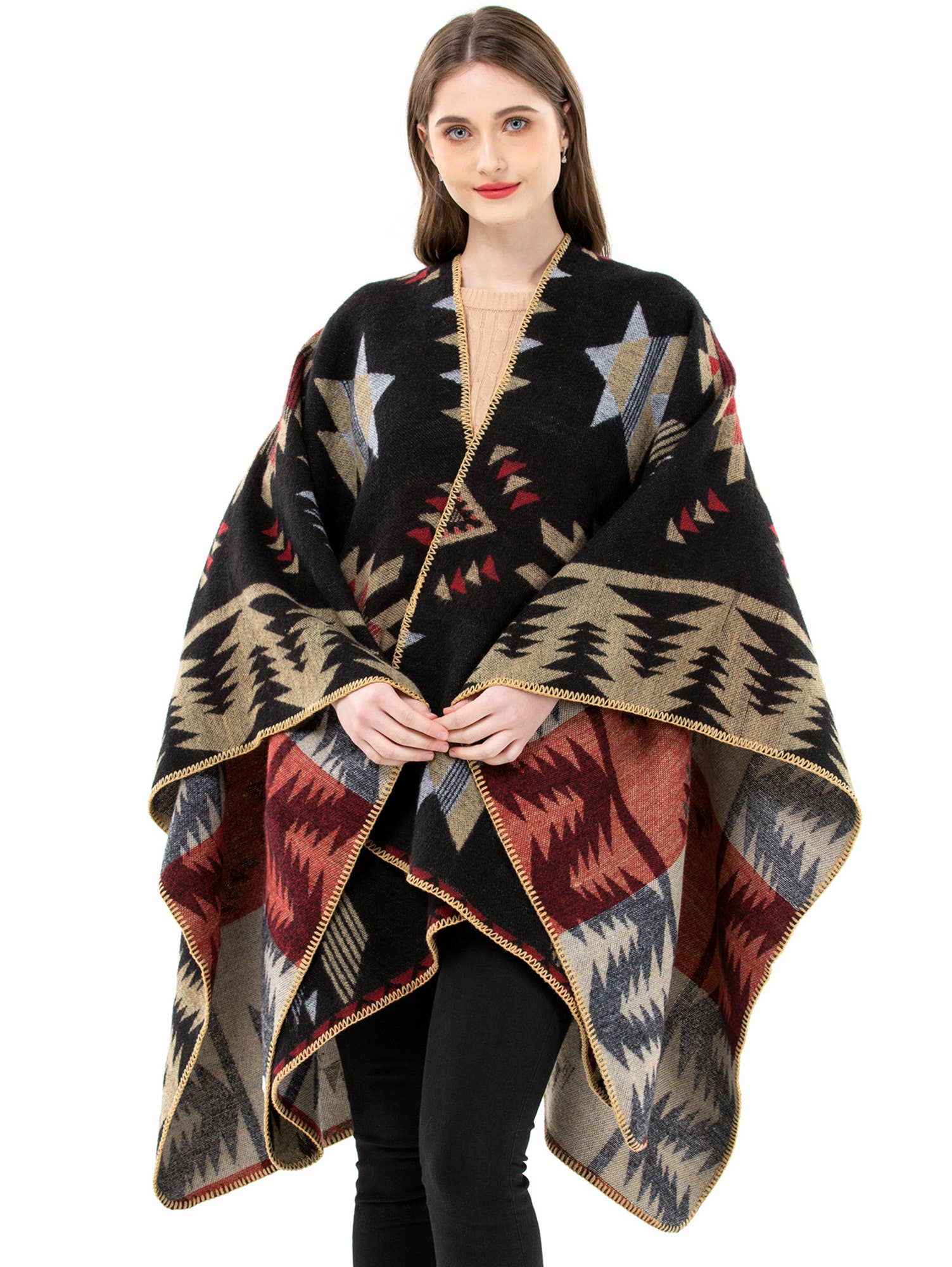 Woman wearing a patterned poncho with stars and geometric designs on a white background
