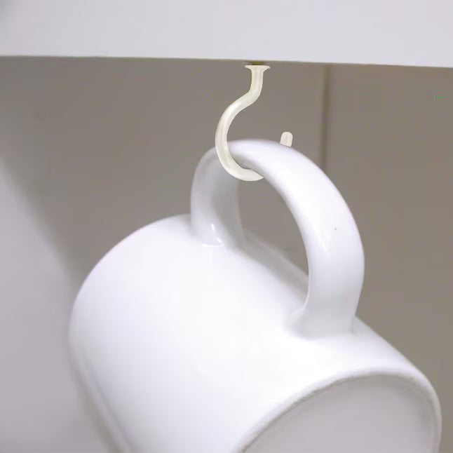 Showing the white hook mounted and holding a coffee mug