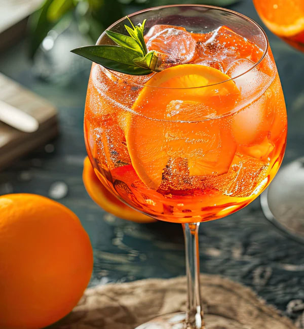 Jordan's Skinny Mix Citrus Spritz flavoring in sparkling water with an orange slice, ice and garlin.