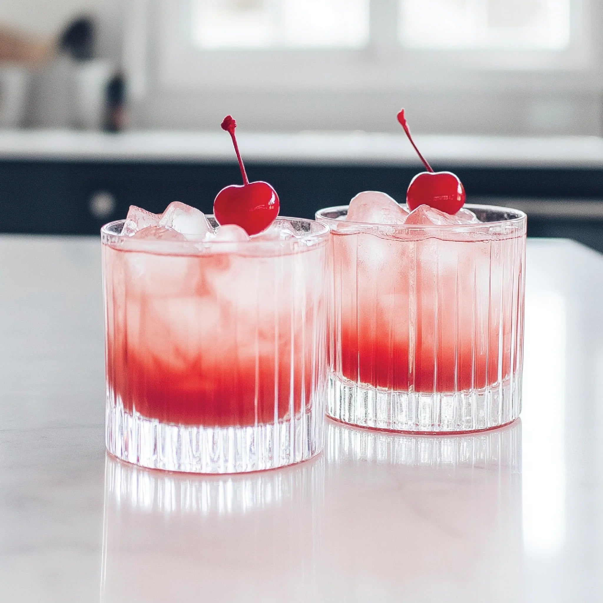 Jordan's Skinny Mix Grenadine syrup flavored adult beverages in glass with a cherry for garnish.