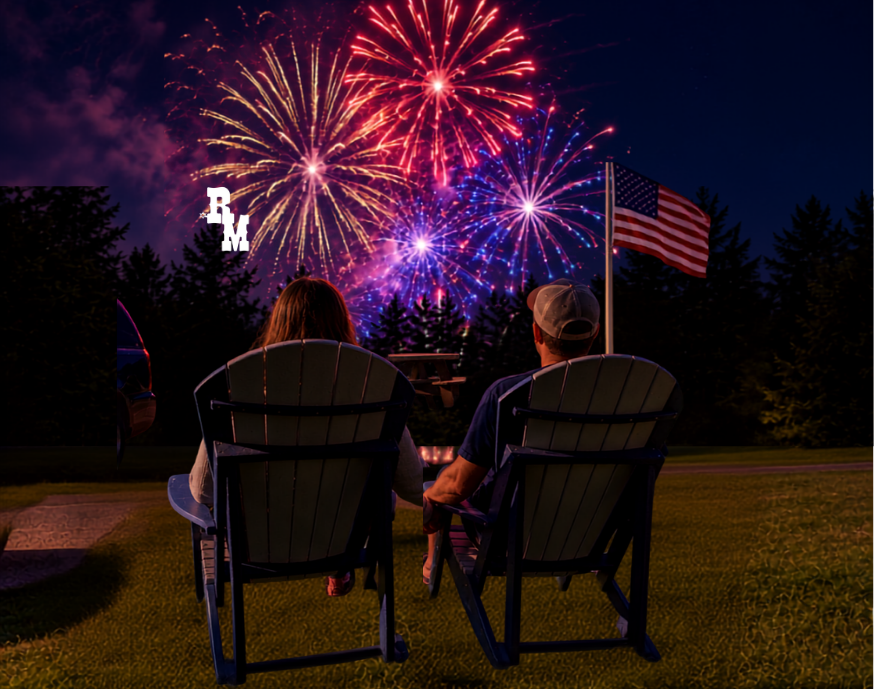 Two people watching fireworks display with American flag in background