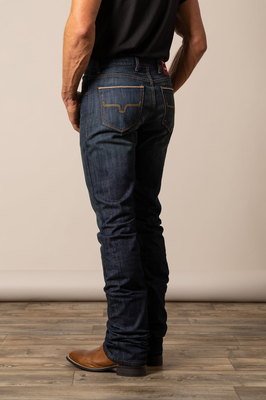 Person wearing dark blue Kimes Ranch jeans in the style Roger, showcasing hide pockets. 