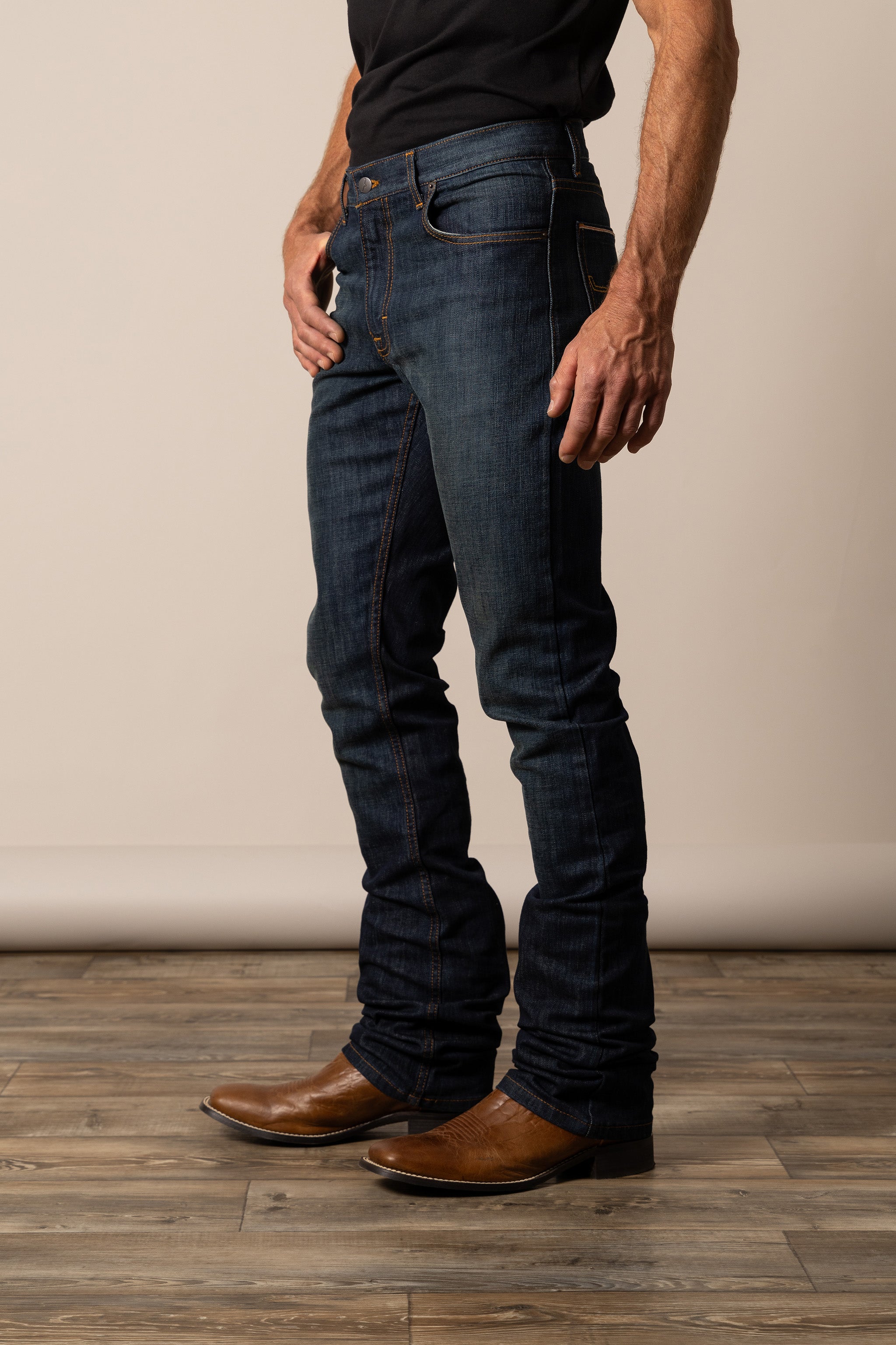 Person wearing dark blue Kimes Ranch jeans in the style Roger and brown boots 