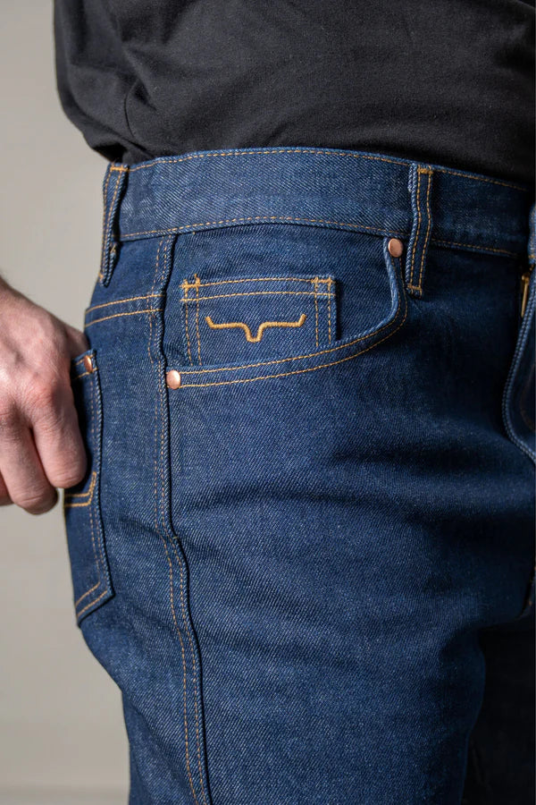 Close-up of Kimes Ranch Zach Top blue jeans with a brand logo on the pocket.