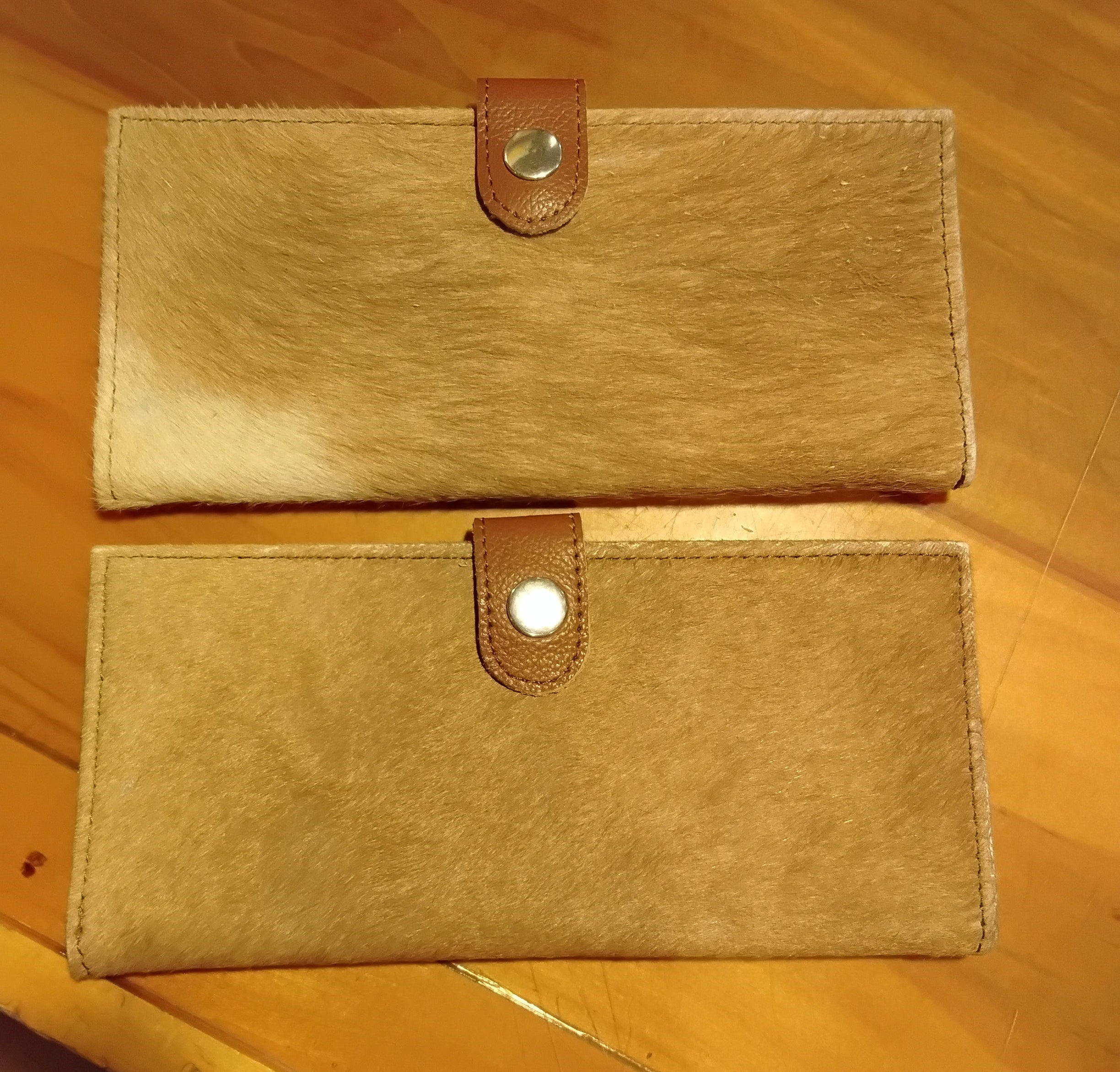cowhide checkbook wallet in a light brown color