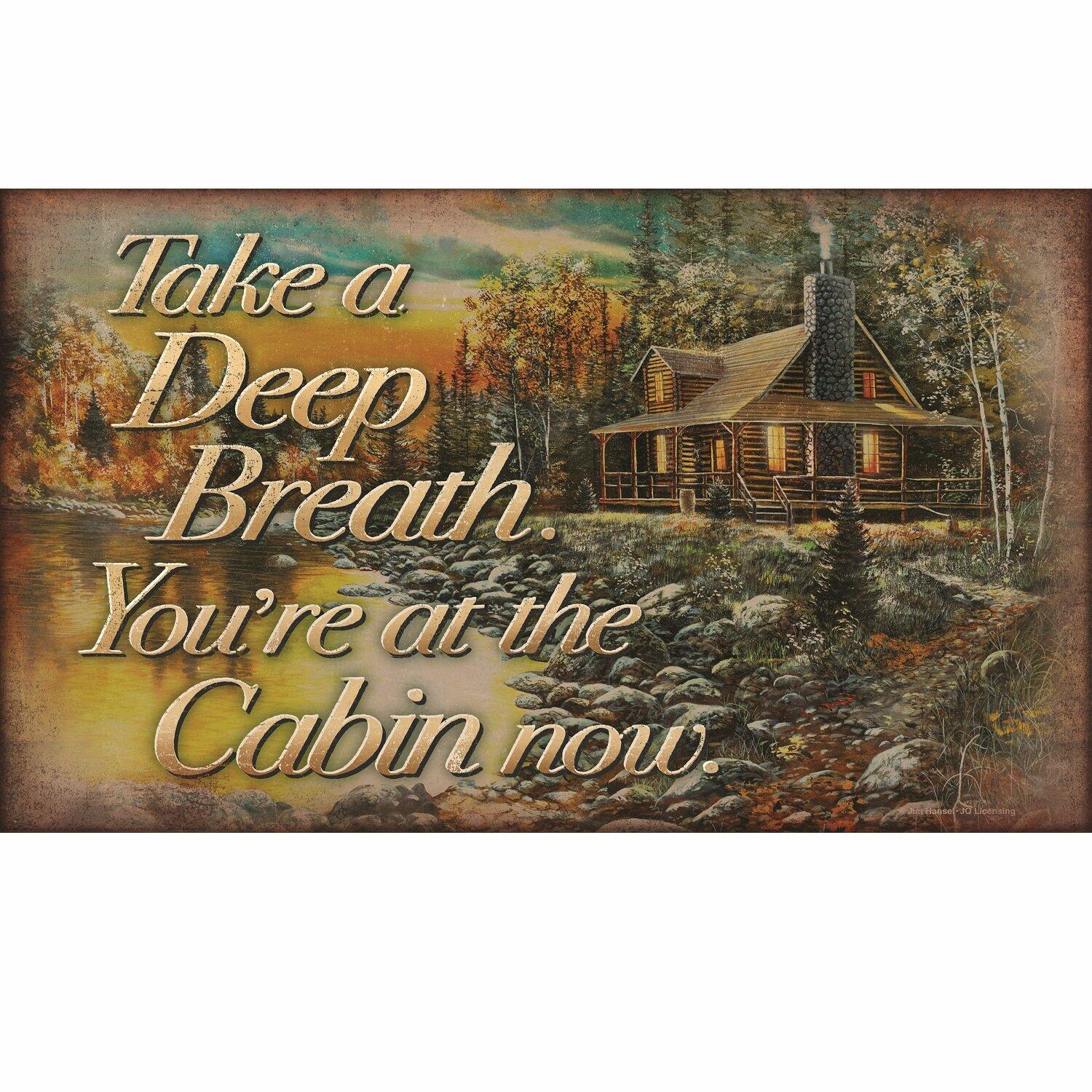 Cabin in a forest with a scenic view and text 'Take a Deep Breath. You're at the Cabin now.'