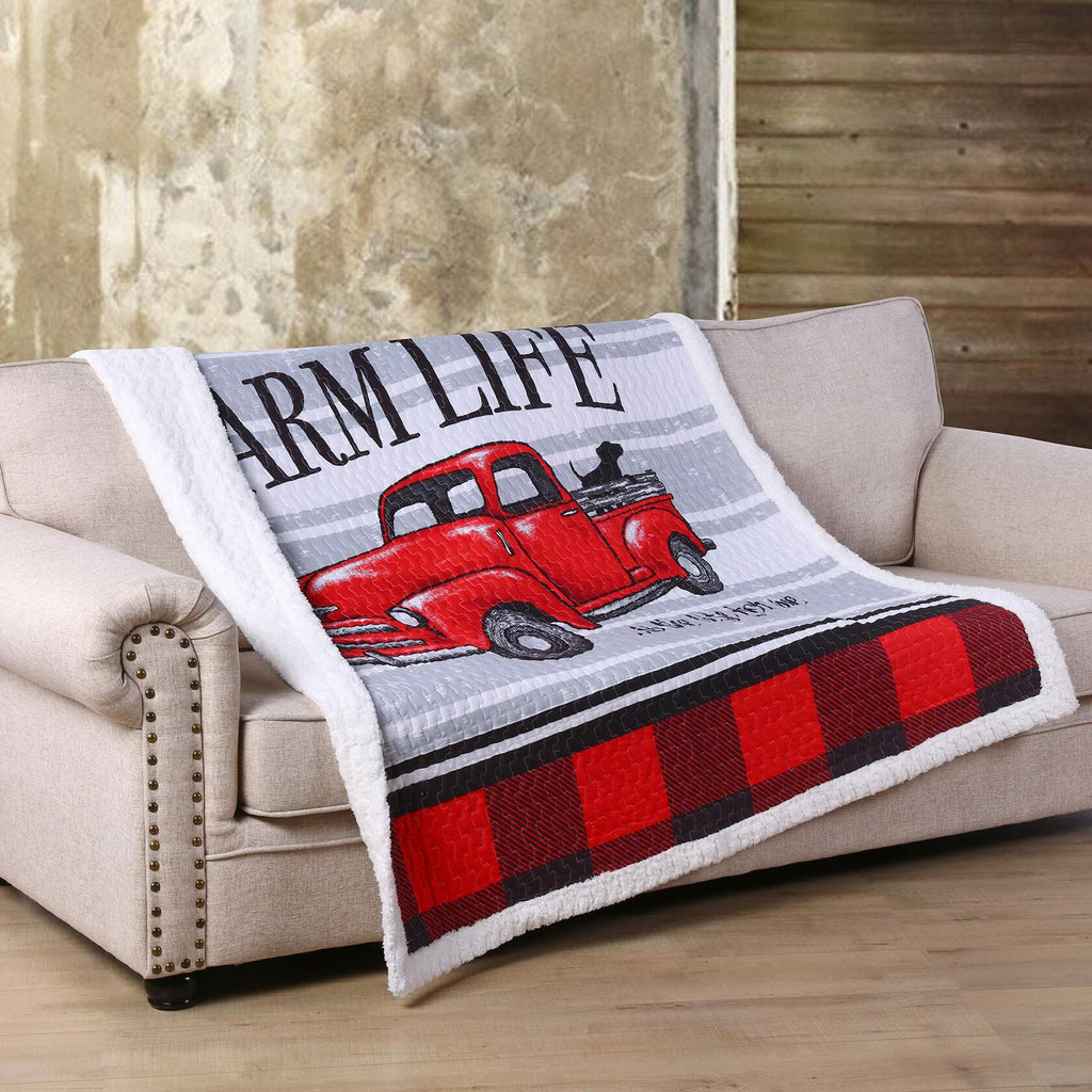 Blanket with 'Farm Life' and red truck design draped over a beige sofa.