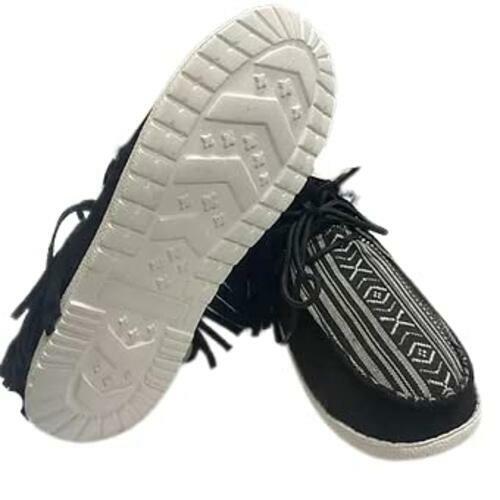 Black suede shoe with tassel and decorative pattern on a white background