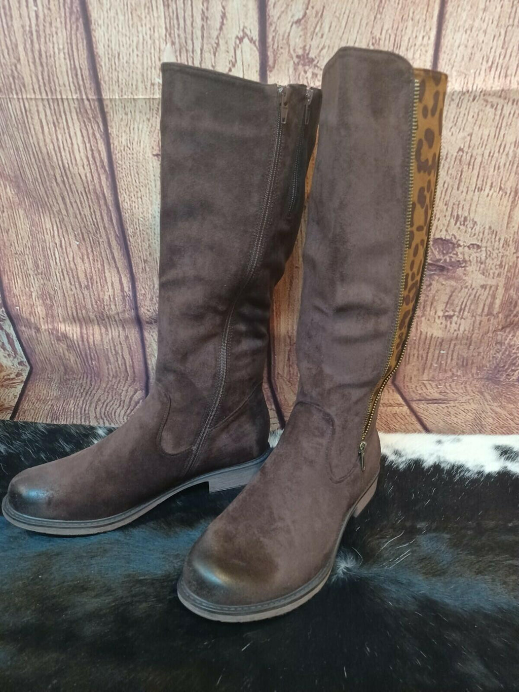 Pair of brown knee-high boots on a wooden floor