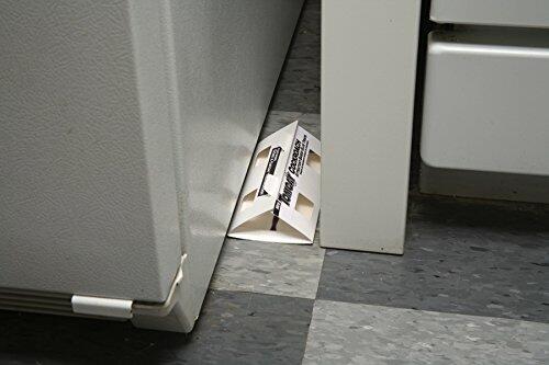 Mouse trap placed under a refrigerator on a concrete floor