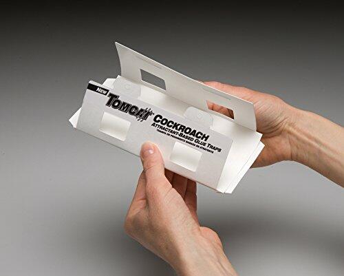 Tomcat cockroach glue traps packaging held by a hand on a gray background