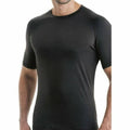 Man wearing a black short-sleeve compression shirt on a white background