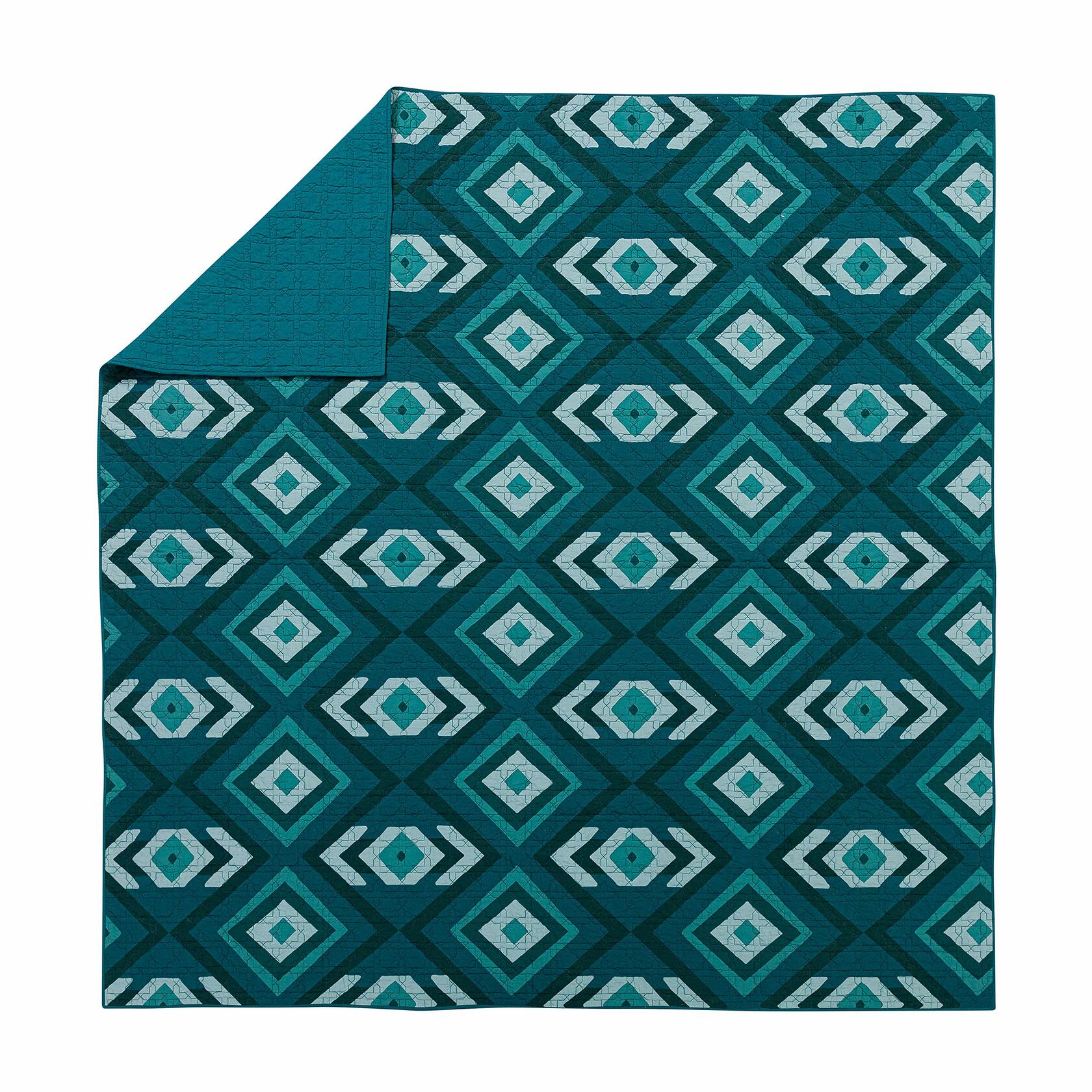 Teal and white geometric patterned blanket on a white background