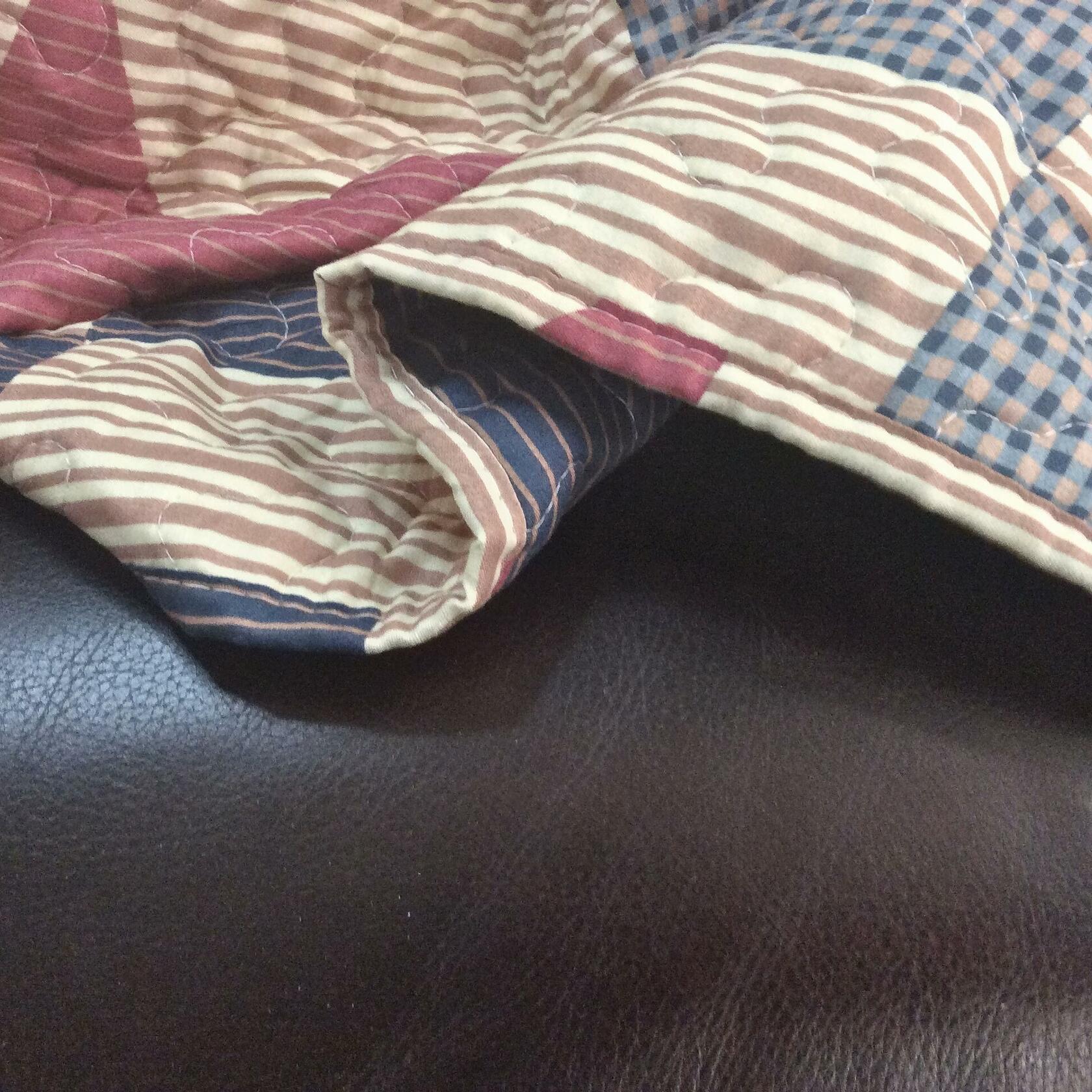 Quilt with striped and checkered patterns on a dark surface
