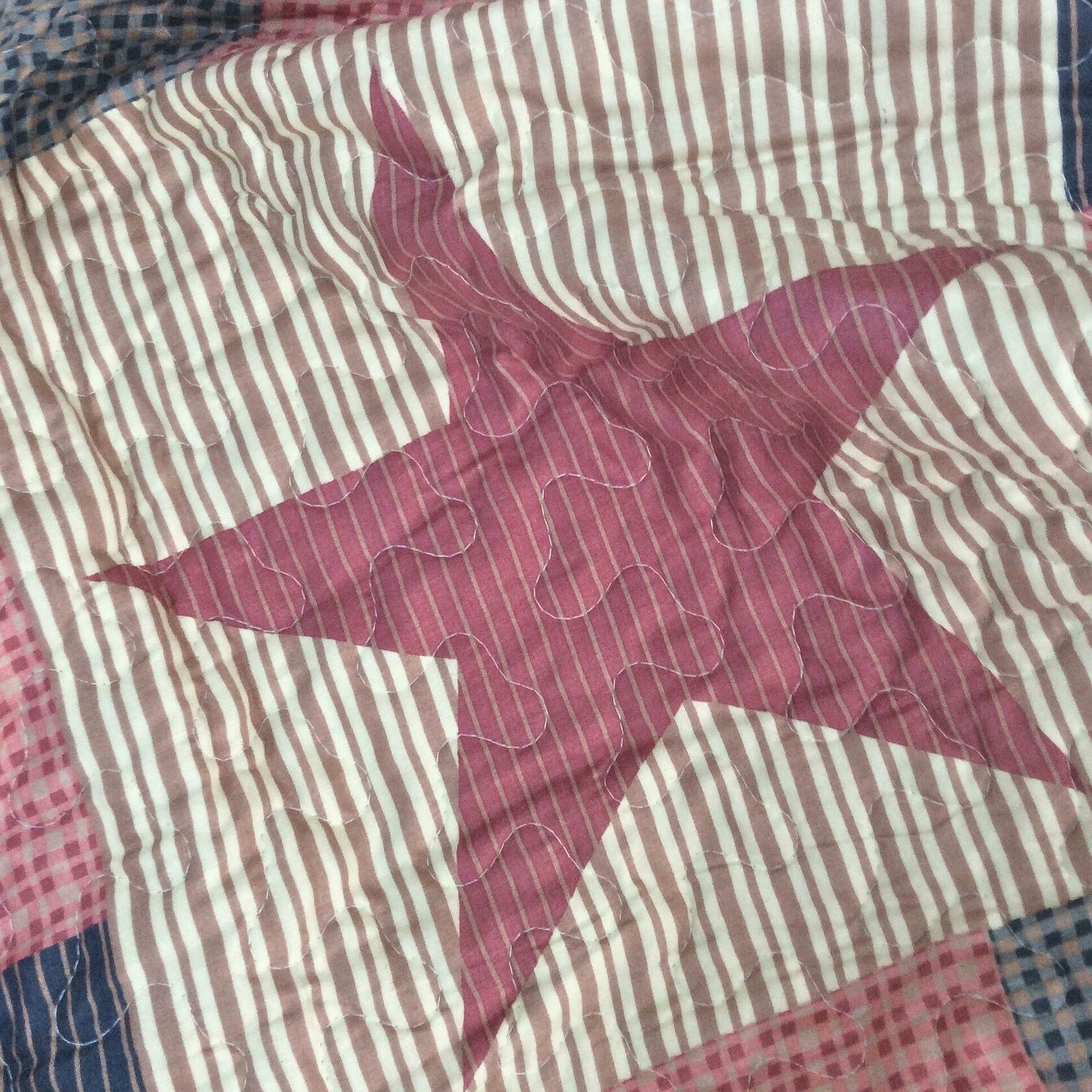 Patchwork quilt with a large star design in red, white, and blue.