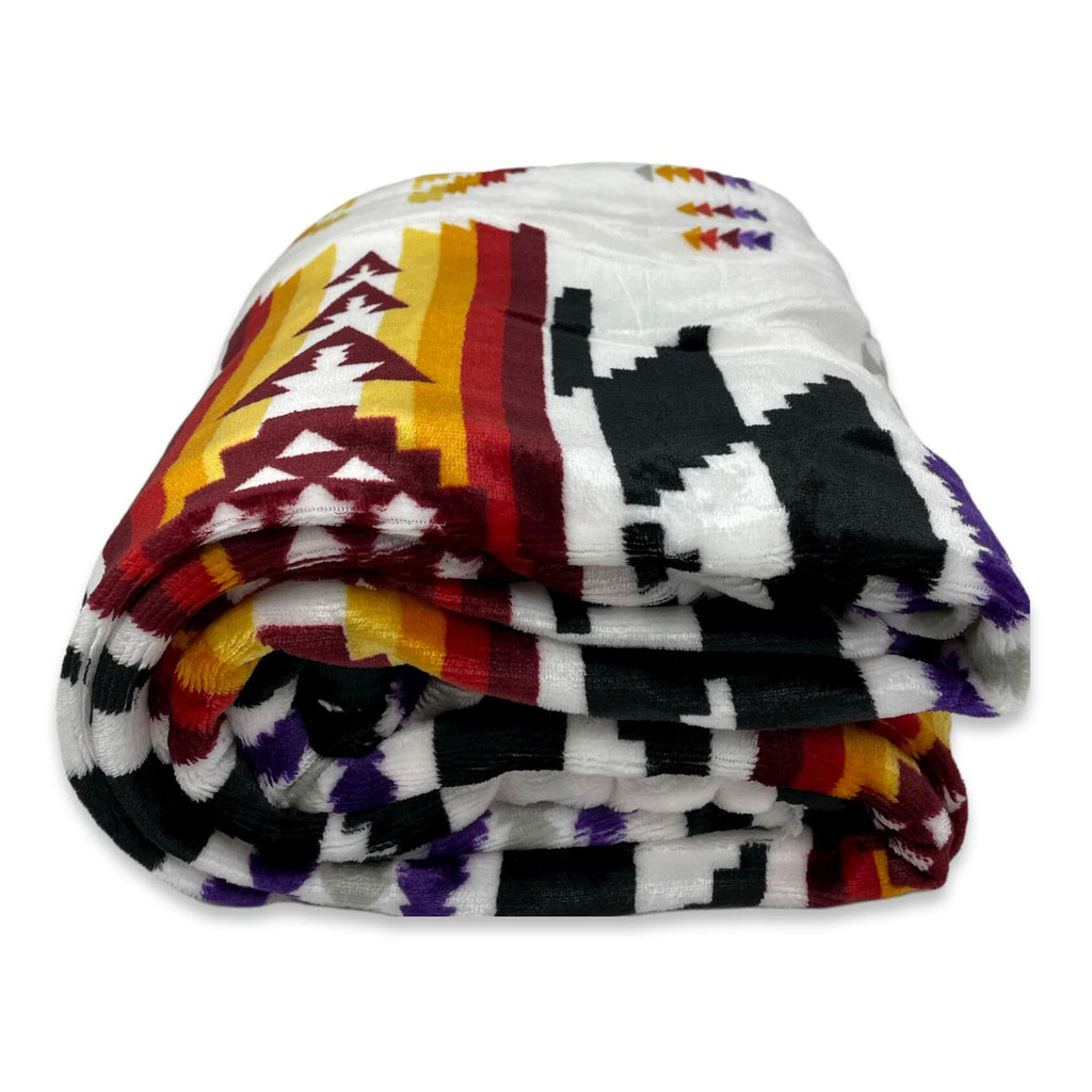 Folded blanket with geometric pattern on a white background