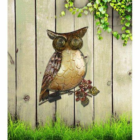 Metal owl sculpture on a wooden wall with greenery