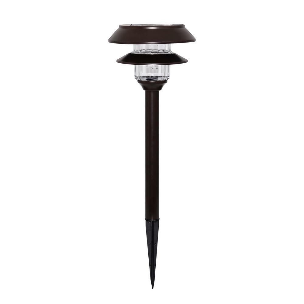 Solar-powered garden light with brown top and black stake on a white background