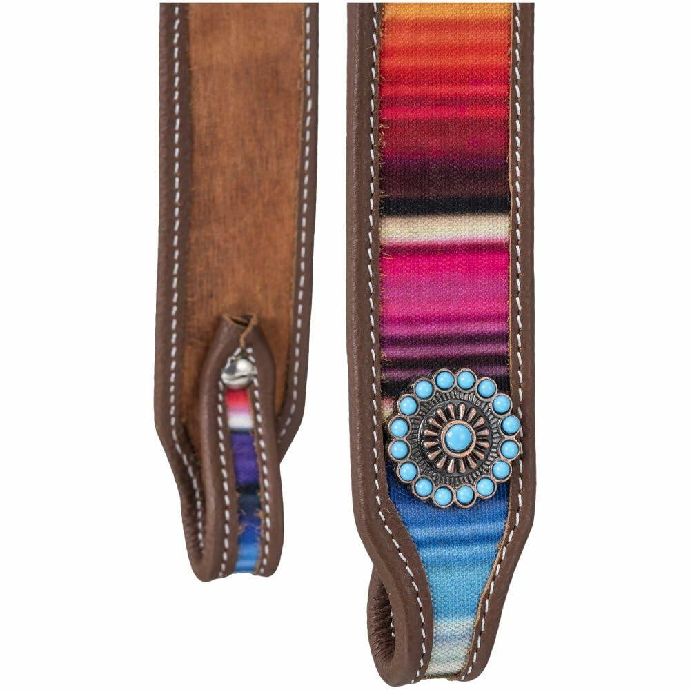 Colorful serape-style strap with brown leather and turquoise concho on a white background