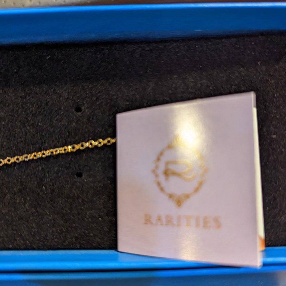 Gold chain on a 'Rarities' branded card with a blue box in the background