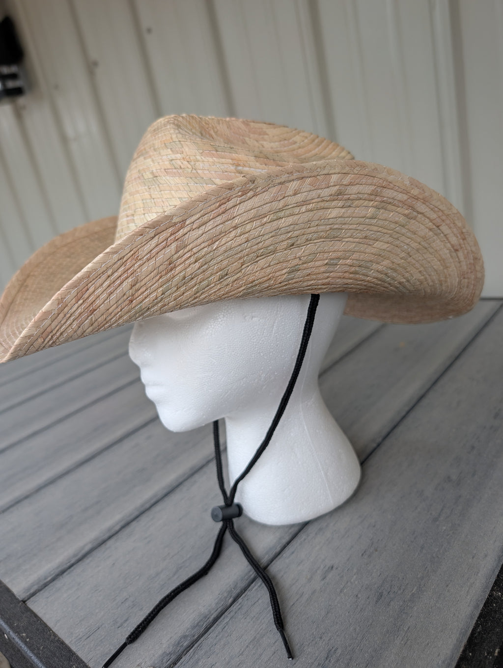 Side view of a Natural woven palm leaf Western hat featuring 3.5-inch brim and black stampede string.