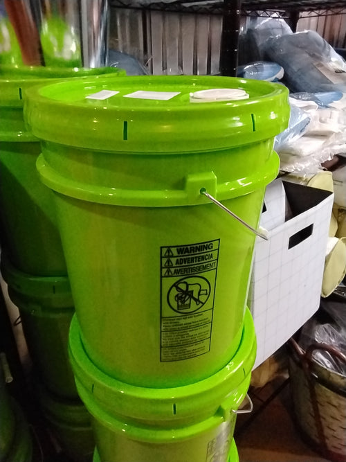 A green plastic container of 5 gallon Gain detergent placed on a shelf.