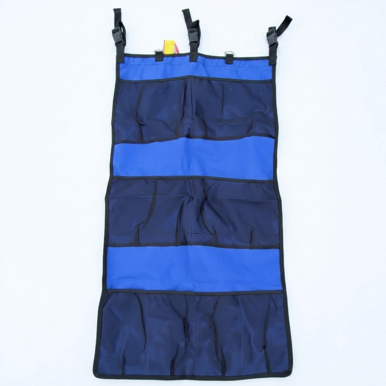 Showman trailer organizer in blue showing the D rings and attachment traps with the three mesh compartments for storage of all types of items