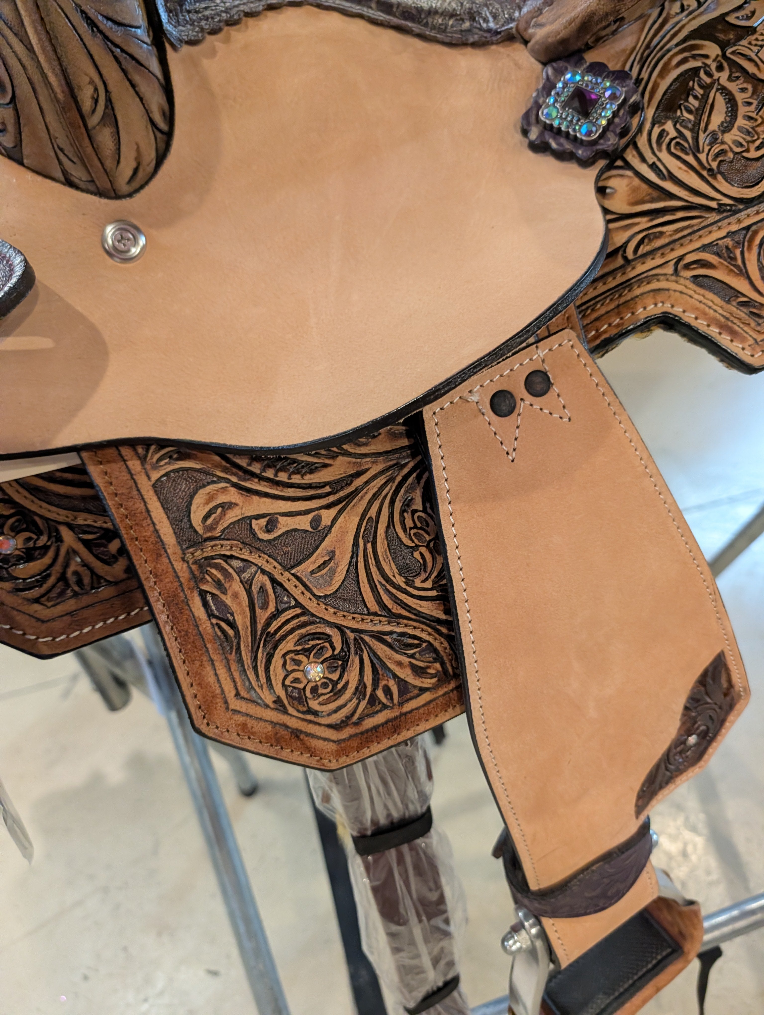Close up of the details of the side of the Silver Royal saddle showing the rough out fender and tooling.