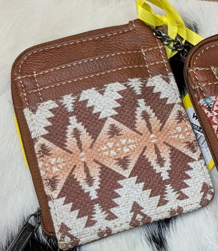 Light coffee brown Wrangler by Montana West Southwestern print mini zip card holder on a black and white cowhide background.