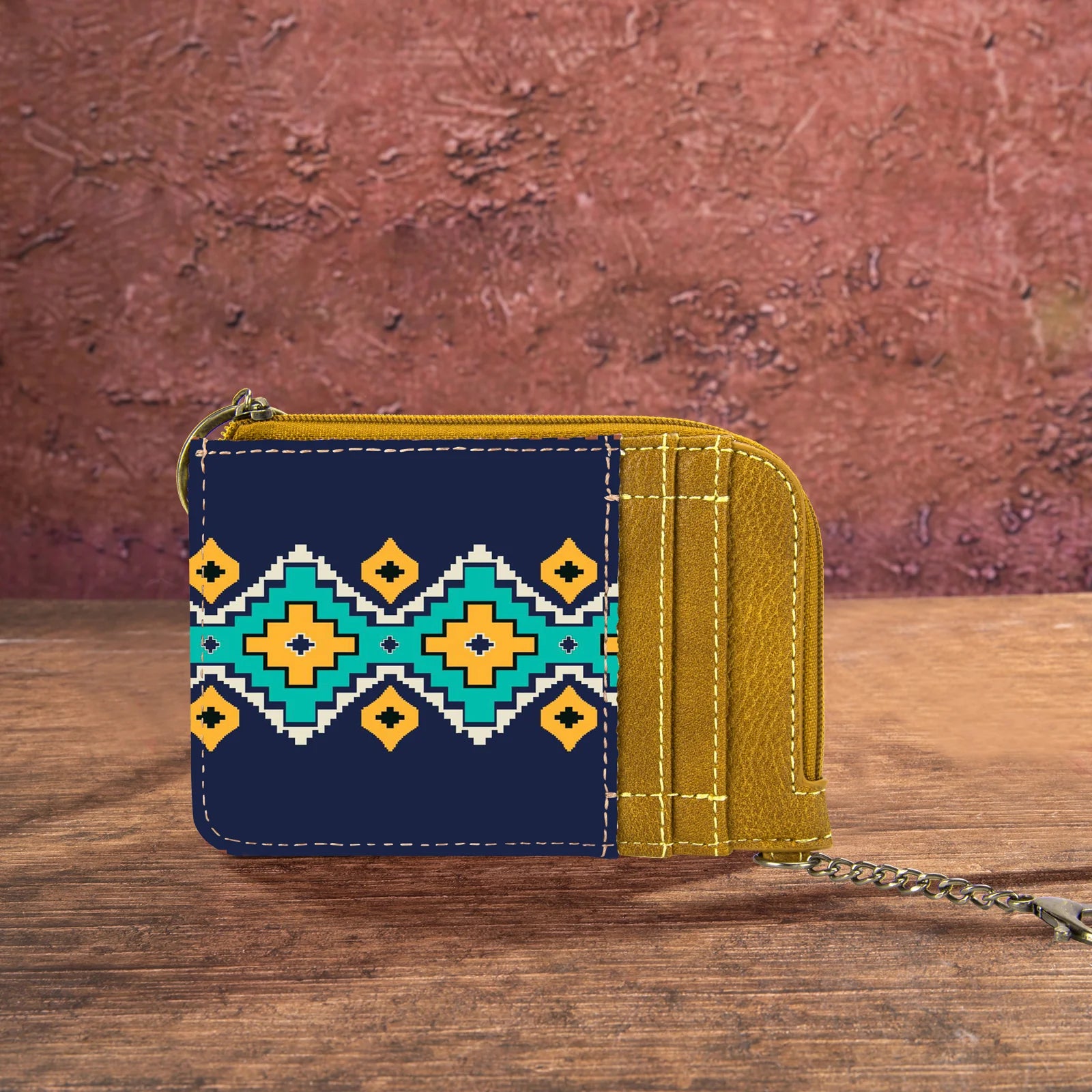 Mustard yellow and navy blue Wrangler by Montana West Southwestern print mini zip card holder on a rustic wooden background.