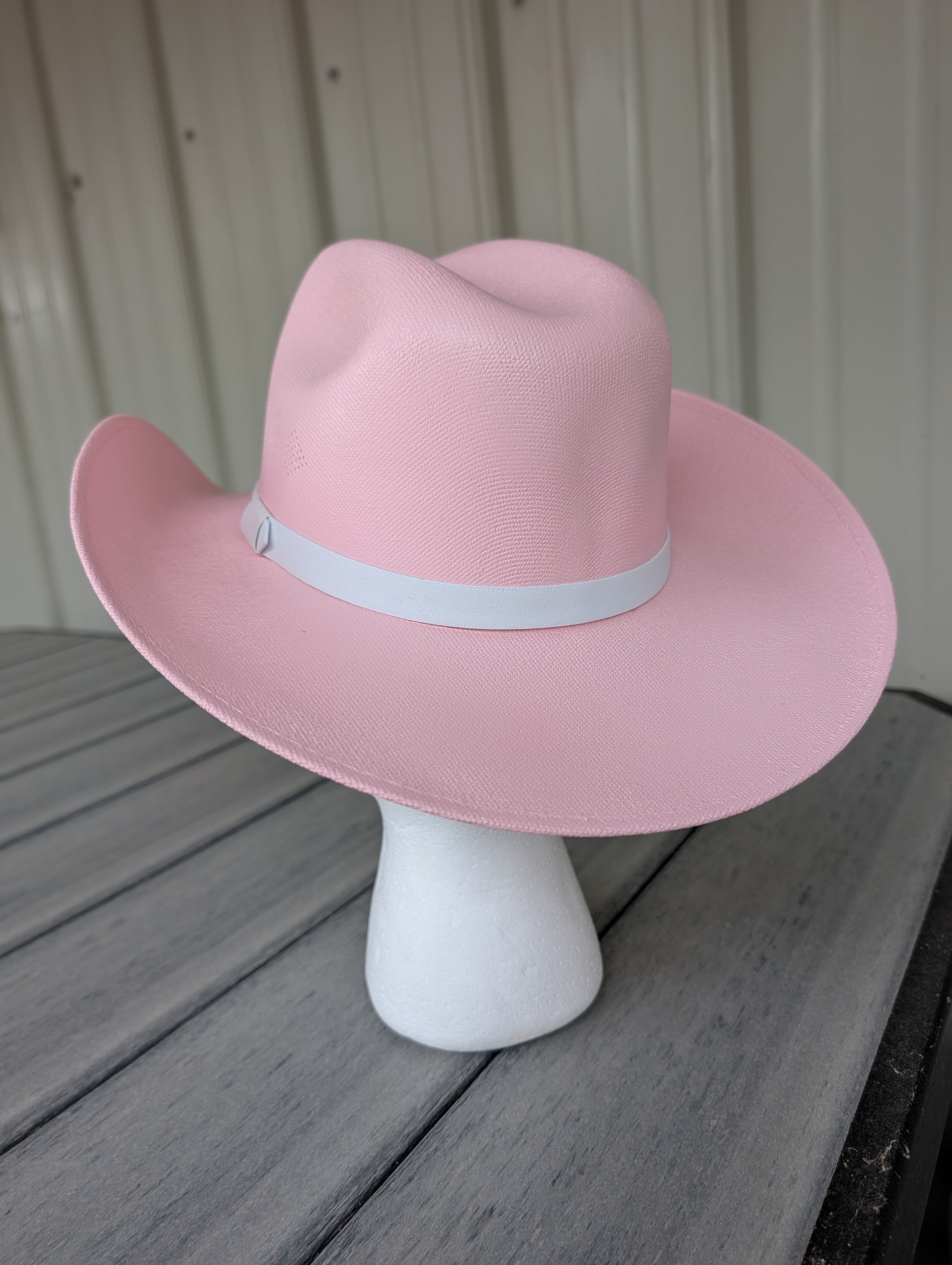 Back view of a pink cowgirl kids hat with a white hat band.