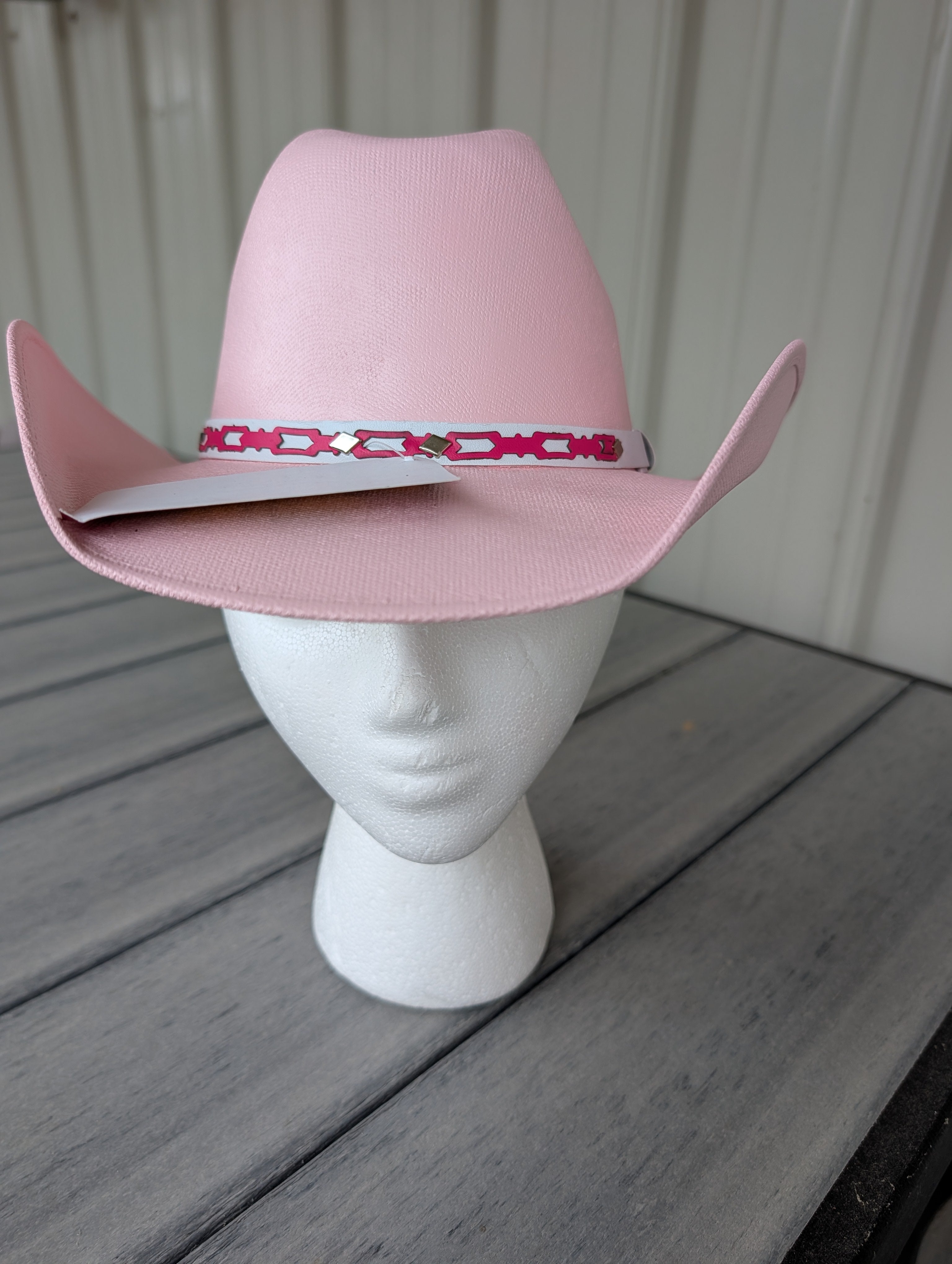 Pink youth cowgirl hat with a decorative pink and white patterned hat band.